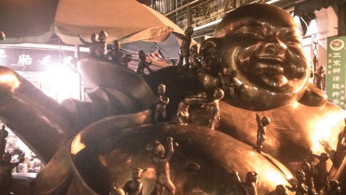 Patung smiling Budha besar di tengah daerah pertokoan dan restoran