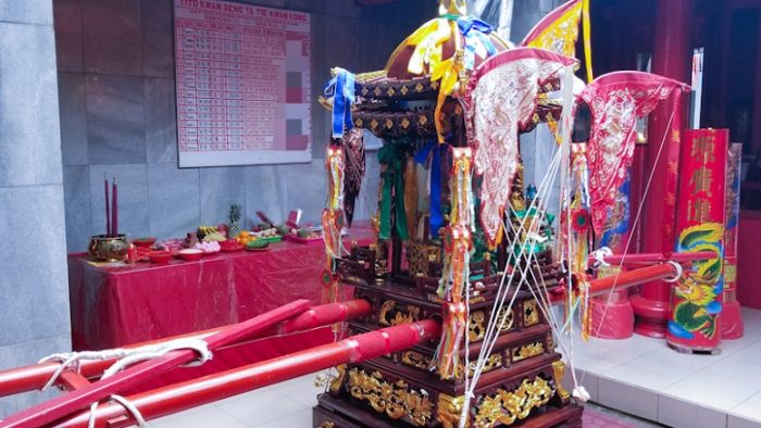 Ukiran emas di kio dengan palang merah siap untuk mengikuti upacara Cap Go Meh