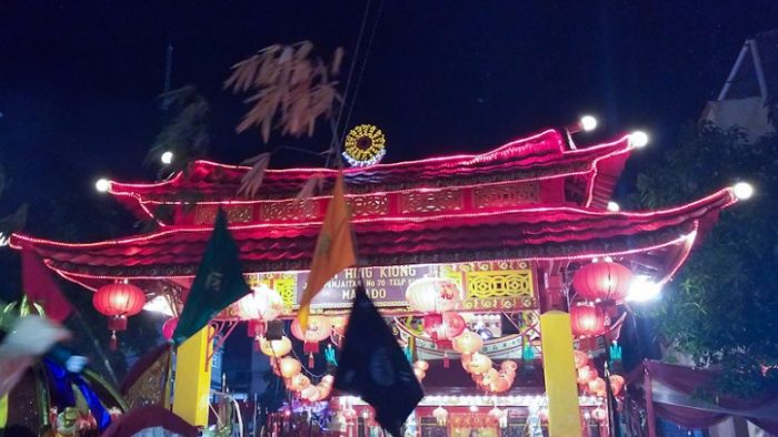 Menutupi ipacara Cap Go Meh dengan membawa bendera dan kio masuk kembali ke Kelenteng Kwan Kong Manado