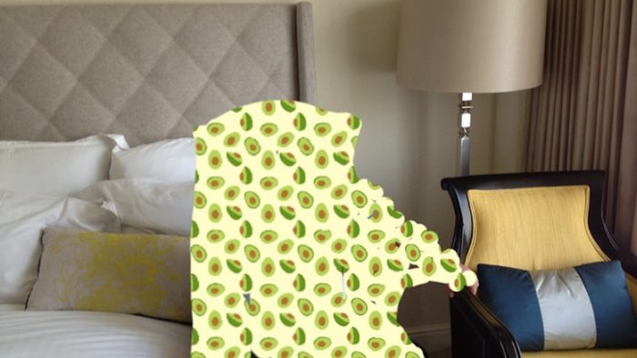 Kursi kayu yang dibalut dengan kain berwarna kuning di kamar tidur