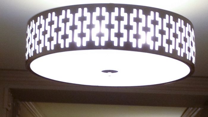 Lampu dengan desain geometris di koridor ke kamar tidur hotel