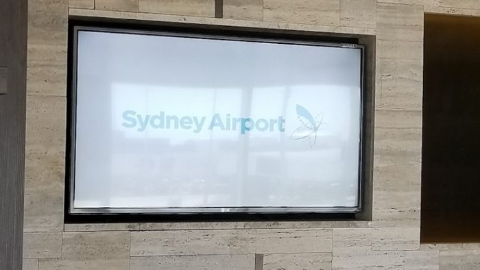 Tanda Sydney Airport di layar TV yang menayangkan informasi penerbangan