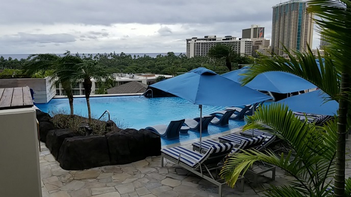 The Ritz-Carlton Waikiki swimming pool Blue water with blue large umbrella