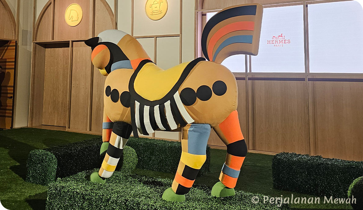 A life-sized, vividly colored horse sculpture with striped and polka-dot patterns at the Hermès exit room