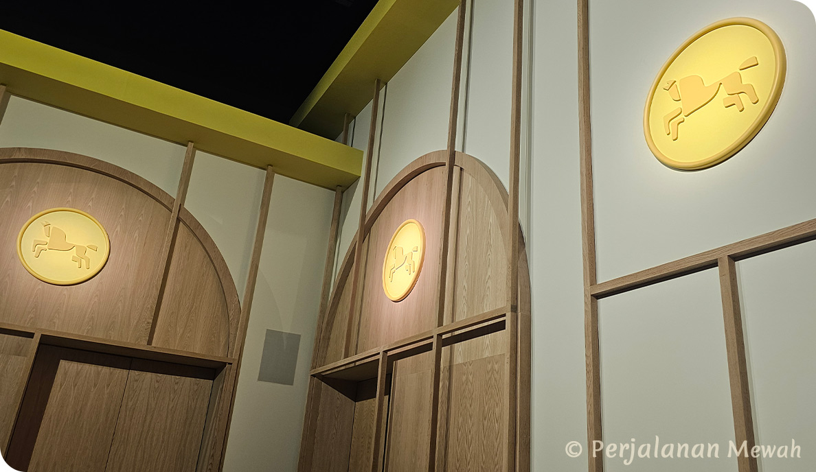 Three horse icons above wooden doors in the corner of Hermès welcome room